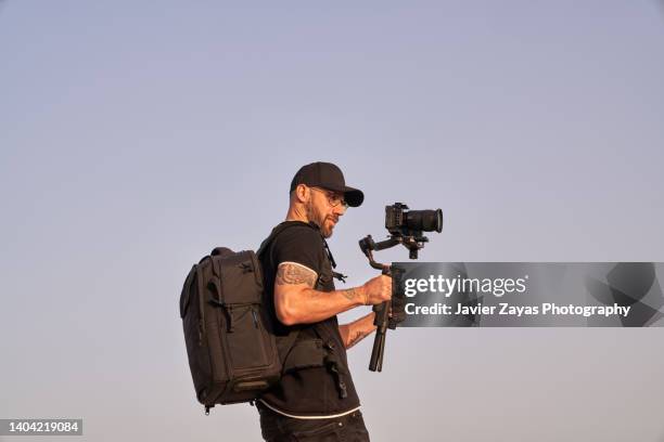 cameraman at work using stabilizer (outdoors) - cameraman photos et images de collection