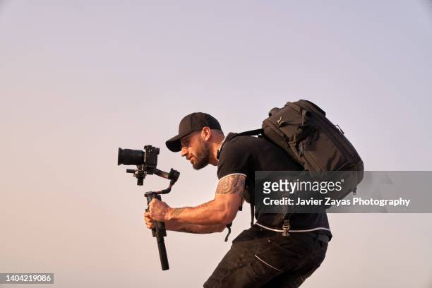 cameraman at work using stabilizer (outdoors) - male photographer stock pictures, royalty-free photos & images