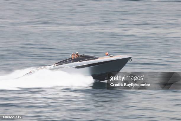 glamorosa pareja de alto vuelo disfrutando del estilo de vida de lujo mientras aceleran en su poderosa lancha rápida en gibraltar - speedboat fotografías e imágenes de stock