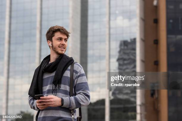 man with headset and cellphone on the street - porto alegre stock pictures, royalty-free photos & images