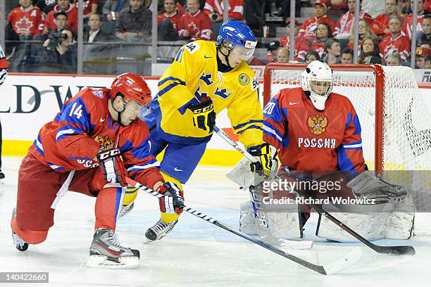 William Karlsson of Team Sweden stick handles the puck in front of Andrei Makarov of Team Russia during the 2012 World Junior Hockey Championship...