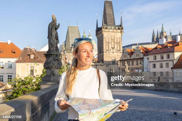 junge alleinreisende mit blick auf den stadtplan - karlsbrücke stock-fotos und bilder