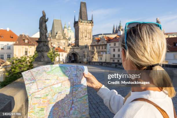 young woman solo traveler looking at city map - prague tourist map stock pictures, royalty-free photos & images