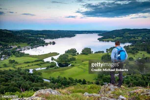 walker on loughrigg fell near ambleside looking towards windermere in the lake district national park - windermere stock pictures, royalty-free photos & images