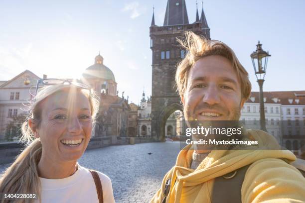 young couple in prague taking a selfie photo to share with friends - czech republic stock pictures, royalty-free photos & images