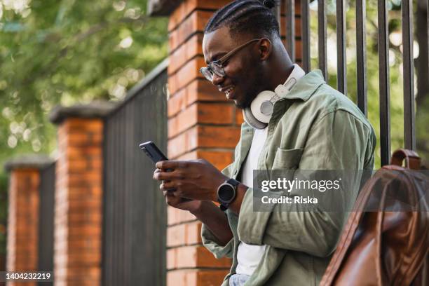 side view of a modern young man using mobile phone in the city - calling on the side road stock pictures, royalty-free photos & images