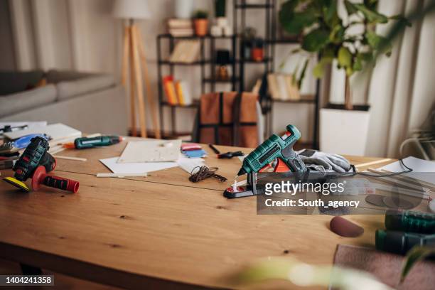 arbeitsgeräte auf dem tisch in der werkstatt - arbeitshandschuhe stock-fotos und bilder