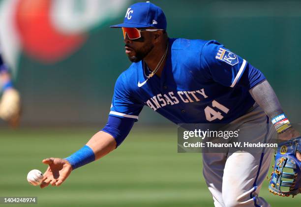 Carlos Santana of the Kansas City Royals underhands the ball to the pitcher covering first base against the Oakland Athletics in the bottom of the...