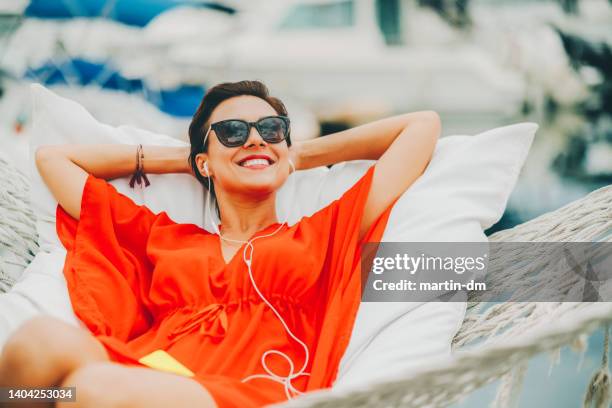 woman in hammock feeling relaxed - tuniek stockfoto's en -beelden