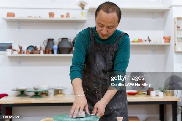 an asian man making a clay sculpture - pottery wheel stock pictures, royalty-free photos & images