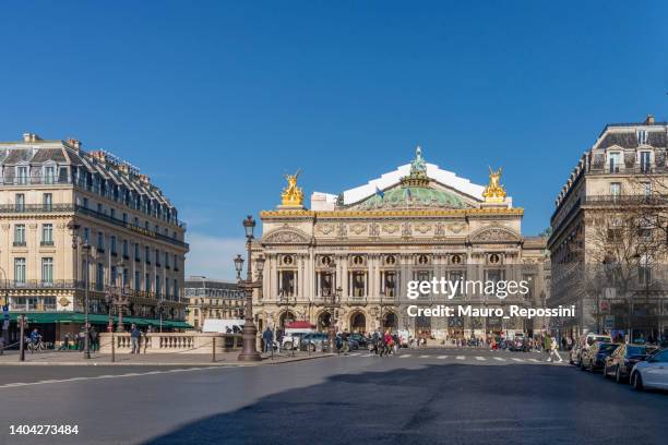 people walking in the place de l´opera (opera square) next to the palais garnier opera house (opera du paris) at paris city, france. - grand opera house stock pictures, royalty-free photos & images