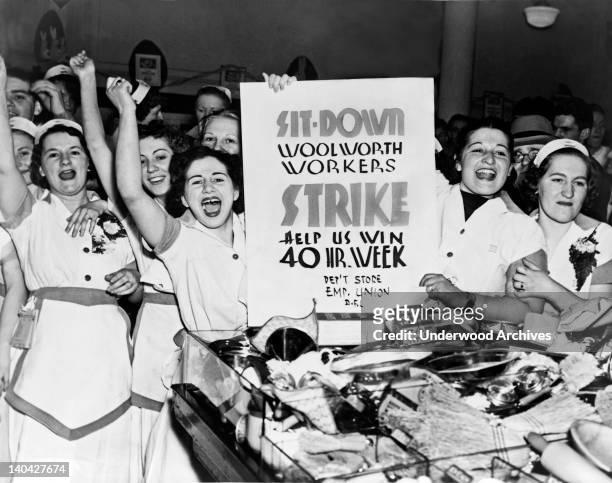 Female employees of Woolworth's holding a sign indicating they are striking for a 40 hour work week, New York, New York, 1937.