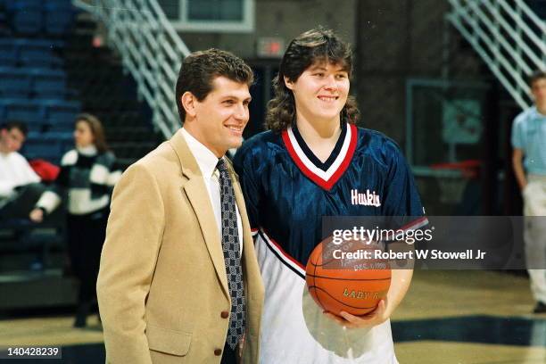 University of Connecticut coach Geno Auriemma stands with player Kerry Bascomb as Bascomb at a presentation for Bascomb's becoming the all-time...