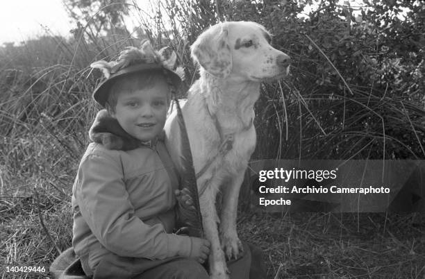 Spanish singer Miguel Bose posing with a hound dog during a hunting trip, Madrid, 1961.