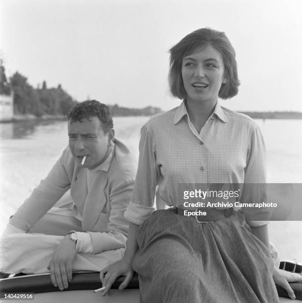French actress Anouk Aimee portrayed while smoking a cigarette with her husband Alexandre Astruc, sitting on a boat, Venice, 1955.