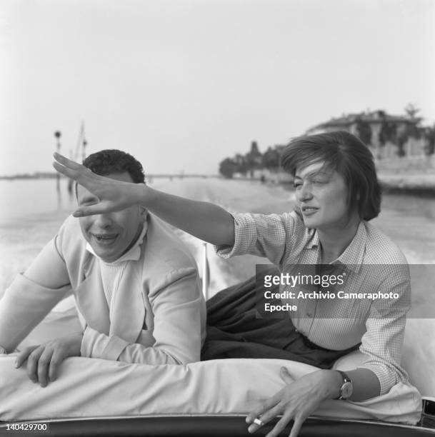 French actress Anouk Aimee portrayed while smoking a cigarette with her husband Alexandre Astruc, lying on a boat, Venice, 1955.