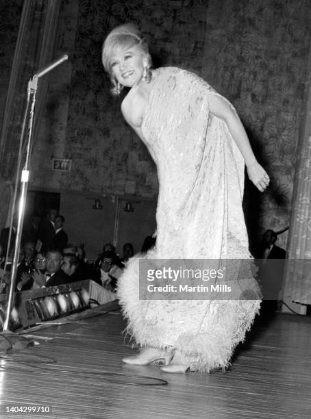 American comedienne, actress, singer and businesswoman Edie Adams , performs during the White House News Photographers' Association Meeting on April...