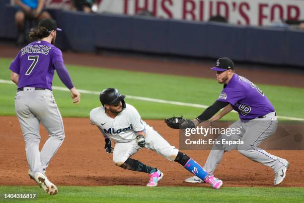 Cron of the Colorado Rockies attempts to tag Miguel Rojas of the Miami Marlins during a run down in the fifth inning of the game at loanDepot park on...