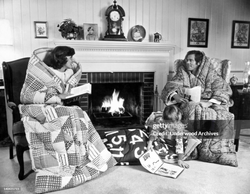 Family Huddled By Fireplace