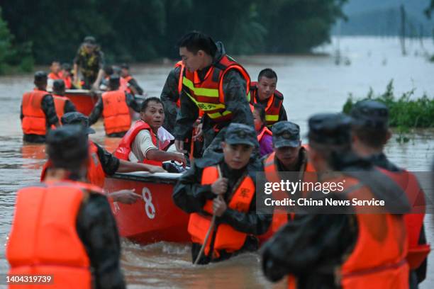 Rescuers evacuate stranded people in flood water on June 21, 2022 in Shaoguan, Guangdong Province of China. Flood control authority of China's...