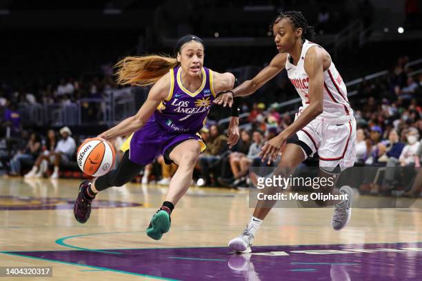 Chennedy Carter of the Los Angeles Sparks drives against Shatori Walker-Kimbrough of the Washington Mystics in the first half at Crypto.com Arena on...