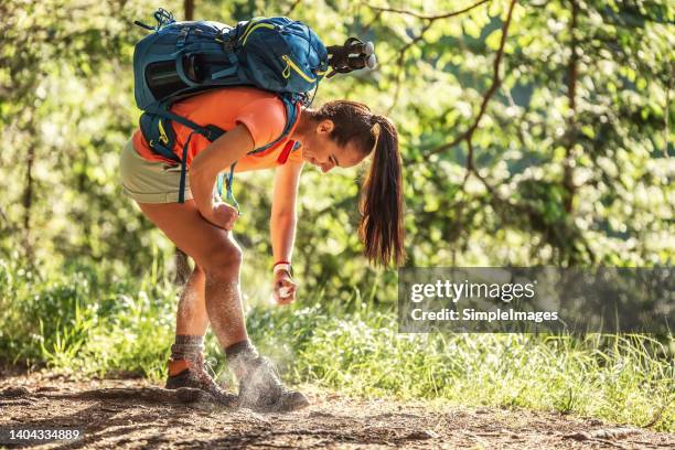 a woman applies mosquito spray to her feet during hiking. - insect spray stock pictures, royalty-free photos & images