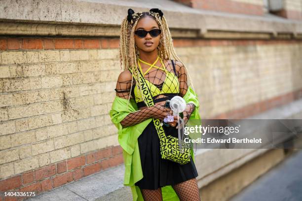 Debbie aka @blackhey wears a black velvet hair elastic, black sunglasses, a silver embossed patter earrings from Givenchi, a large fishnet / mesh...