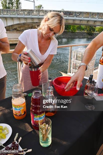 Presenter Cecile de Menibus learns to fix cocktails during the Petanque Gastronomique Party at Paris Yacht Marina Quai de Grenelle on June 21, 2022...