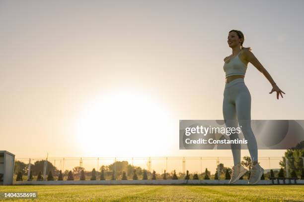 active woman exercise on the soccer field during sunset - form fitted stock pictures, royalty-free photos & images