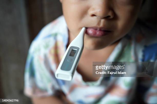 sick little boy with a thermometer in his mouth - fever chills stock pictures, royalty-free photos & images