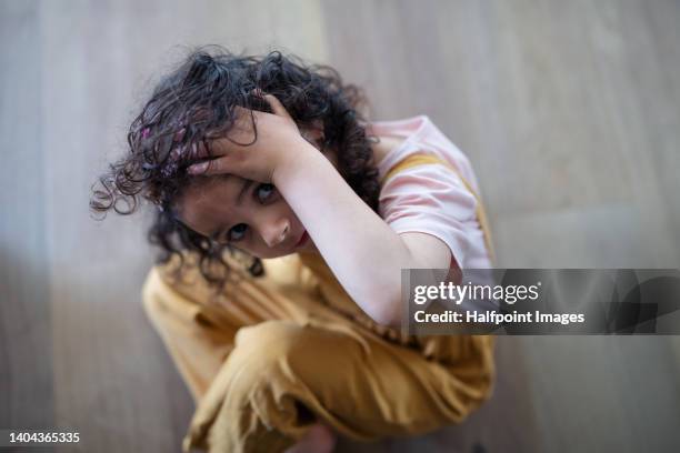 sad little multiracial girl sitting in the floor, worrying. - domestic violence home stock pictures, royalty-free photos & images