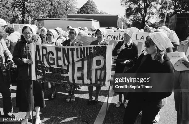 Women hold silent procession in support of foolish mothers of the Plaza de Mayo in Argentina, wearing white headdress with names of missing persons,...