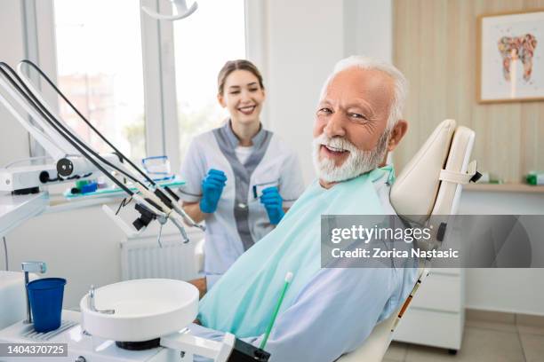 senior man at dentist looking at camera - tandartsstoel stockfoto's en -beelden