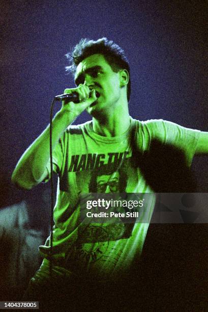 Morrissey of The Smiths performs on stage wearing a 'Hang The DJ' tee shirt at Brixton Academy, on October 24th, 1986 in London, England. The phrase...