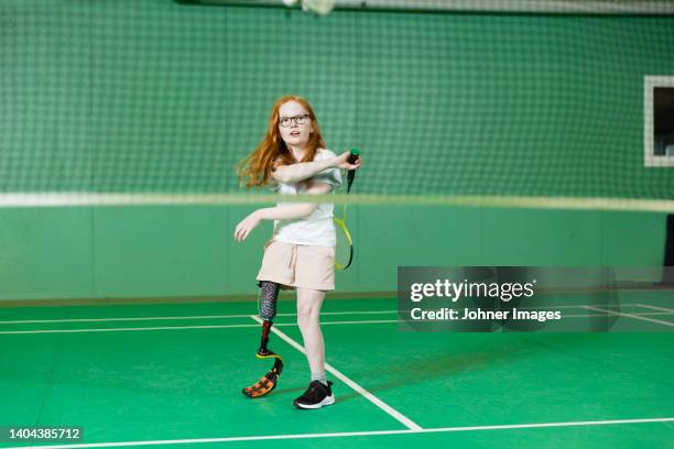 girl with artificial leg playing badminton - badminton sport stockfoto's en -beelden