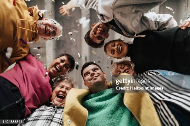 low angle view of happy diverse models, looking at camera. - diverse group stock-fotos und bilder