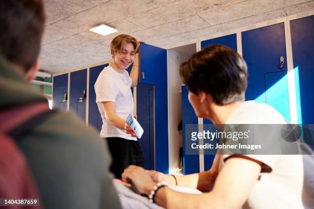 teenage boys using cell phone in locker room - school locker room stock pictures, royalty-free photos & images