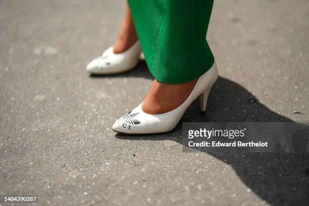 Guest wears a dark green ribbed long tube skirt, white leather pointed pumps heels shoes from Adidas x Gucci, during the Bluemarble show, during...