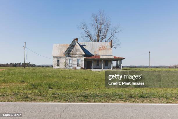 abandoned home with a rusting tin roof in farmland by a road - southeast us stock pictures, royalty-free photos & images