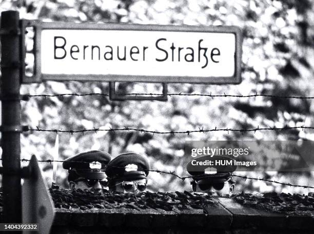 Three Communist 'VOLPO's', East German Police, Stretch to Get a Look Over a Cemetery Wall Which Happens to Run Along the West Berlin Border.