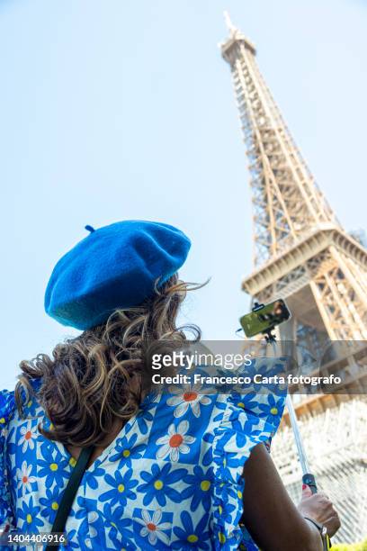 woman taking a selfie with smartphone in the tour eiffel - selfie stick stock pictures, royalty-free photos & images
