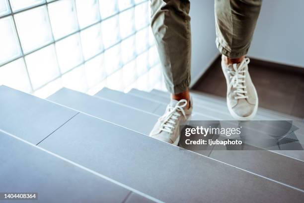 businessman ascending office stairs - tree area stockfoto's en -beelden