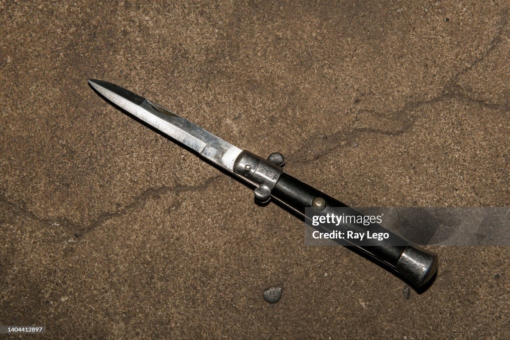 Vintage Switchblade On Ground With School Book HighRes Stock Photo