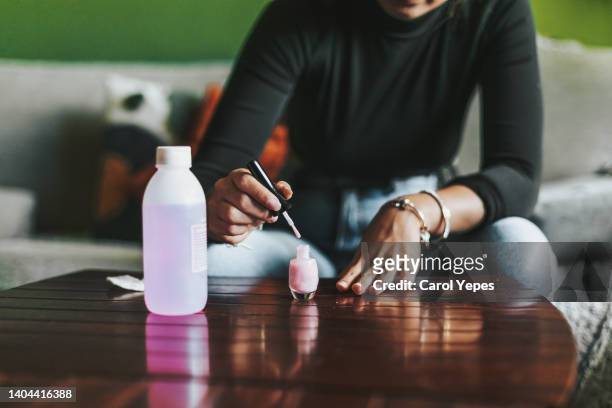 close up of woman with long, slender fingers, paints her nails at home - nagelhaut stock-fotos und bilder