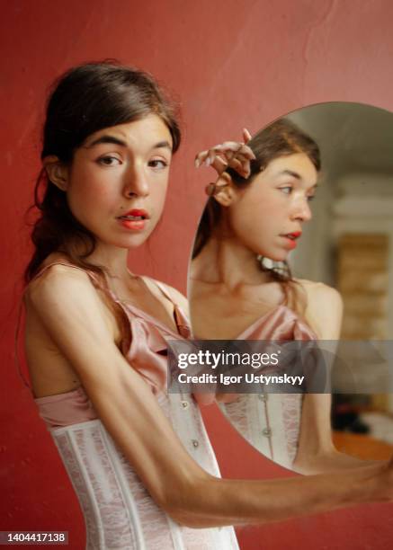 young woman holding circle mirror - vintage corset stock-fotos und bilder