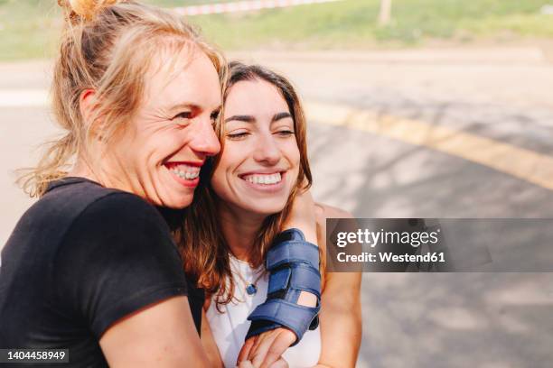 happy woman embracing friend at skateboard park - scandinavian descent stock pictures, royalty-free photos & images