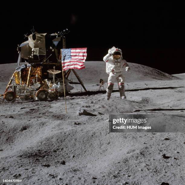 --- Astronaut John W. Young, commander of the Apollo 16 lunar landing mission, leaps from the lunar surface as he salutes the United States flag at...