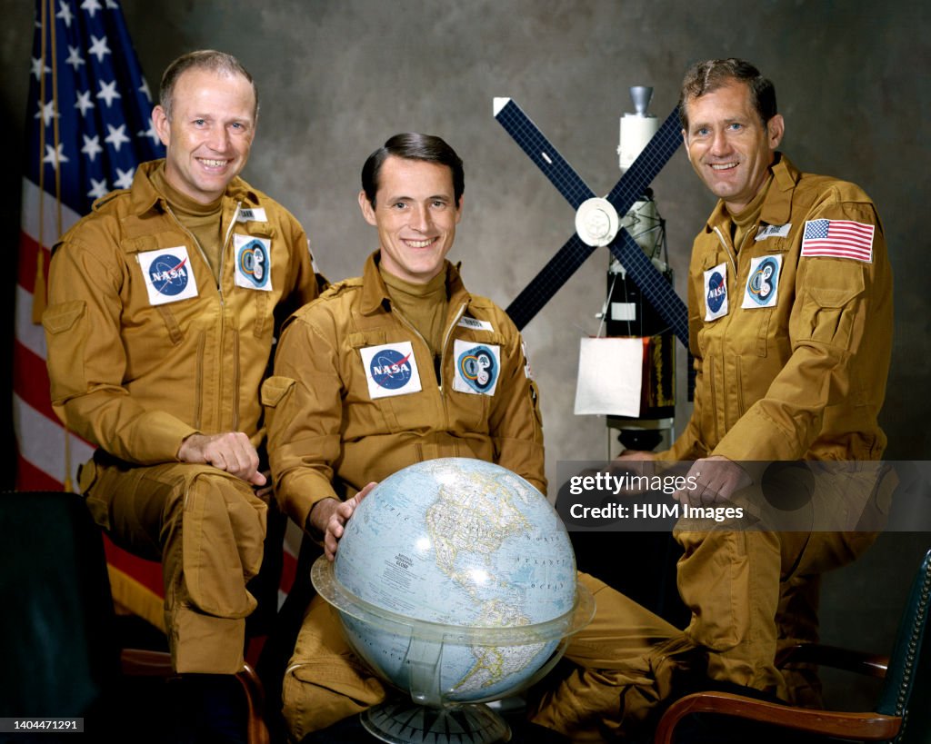 (August 1973) --- These three men are the prime crewmen for the Skylab 4 mission. Pictured in their flight suits with a globe and a model of the Skylab space station are, left to right, astronaut Gerald P. Carr, commander; scientist-astronaut Edward G. Gi