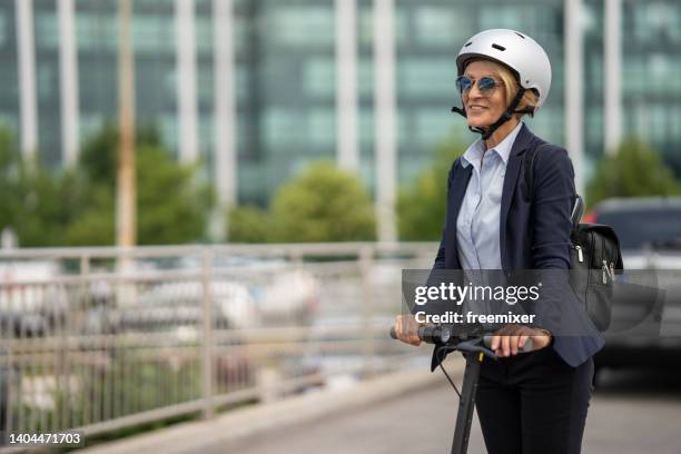 mature woman commuting to work - push scooter stock pictures, royalty-free photos & images