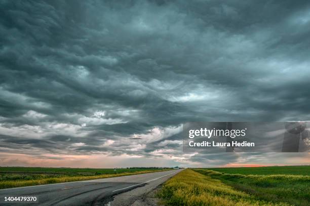 the road leading into the storm - cielo dramático fotografías e imágenes de stock
